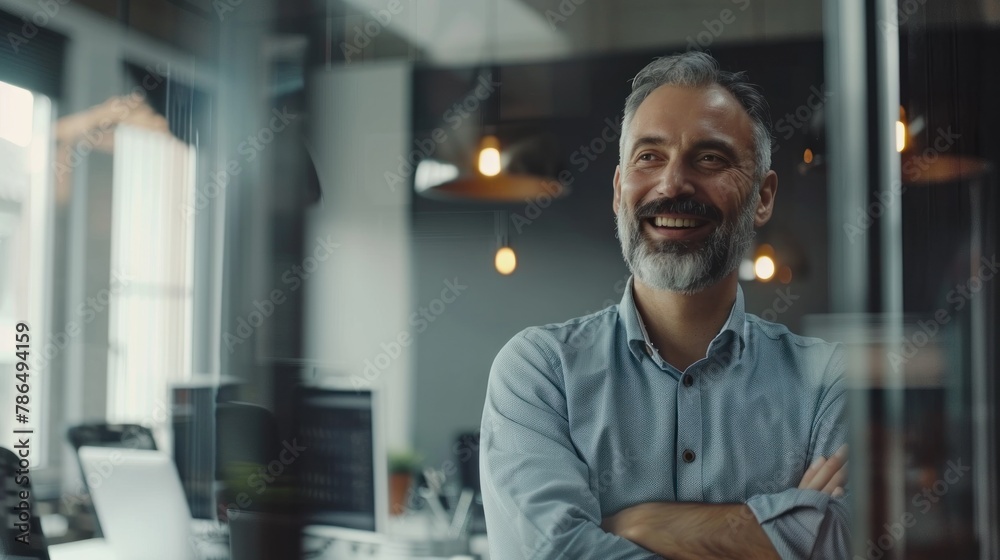 A cheerful manager leading a discussion with his team, seen through the transparent walls of the meeting room.