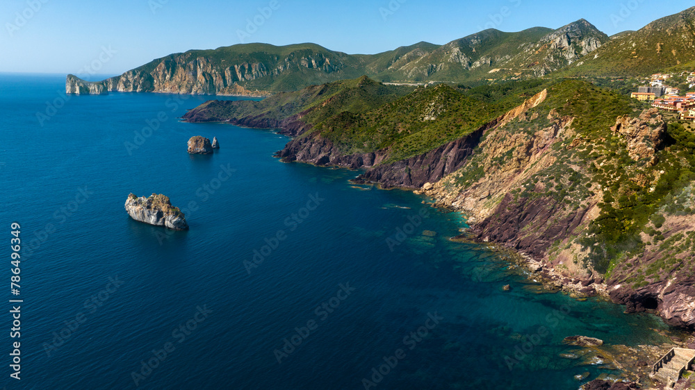 Aerial view of a rocky coast near Porto Flavia in southern Sardinia, Italy. The sea is crystal clear, clean and with colors ranging from blue to turquoise.