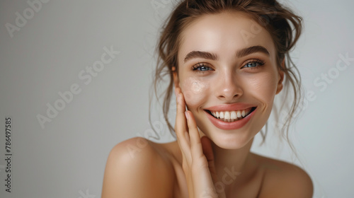 High-resolution cropped photograph showcasing skincare and cosmetics concept  featuring ample space for text. A woman with a stunning visage gently caresses her radiant  healthy facial skin in the por