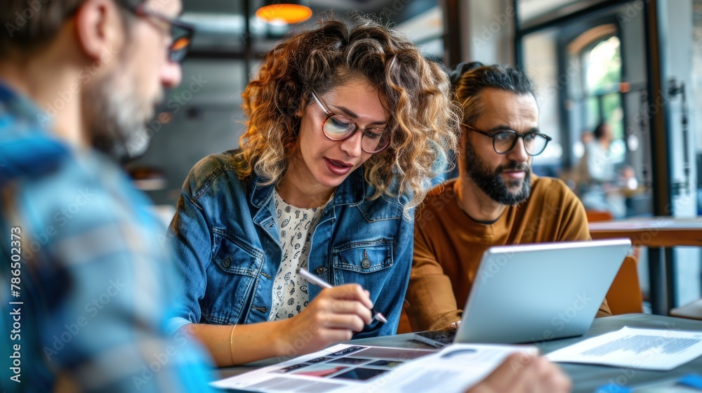A female entrepreneur discussing plans with a male colleague on a tablet, with coworkers actively participating and communicating in the workplace. A female entrepreneur discussing plans with a male colleague on a tablet, with coworkers actively participating and communicating in the workplace.