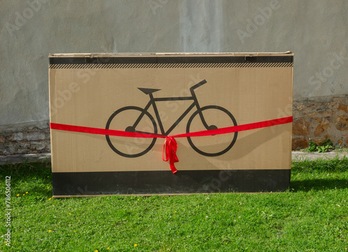 Oversized package with bike image, cinched by bright red ribbon