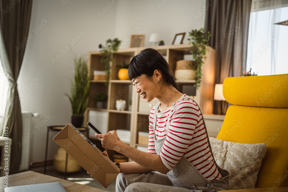 Woman scan qr code of received package use mobile phone at home