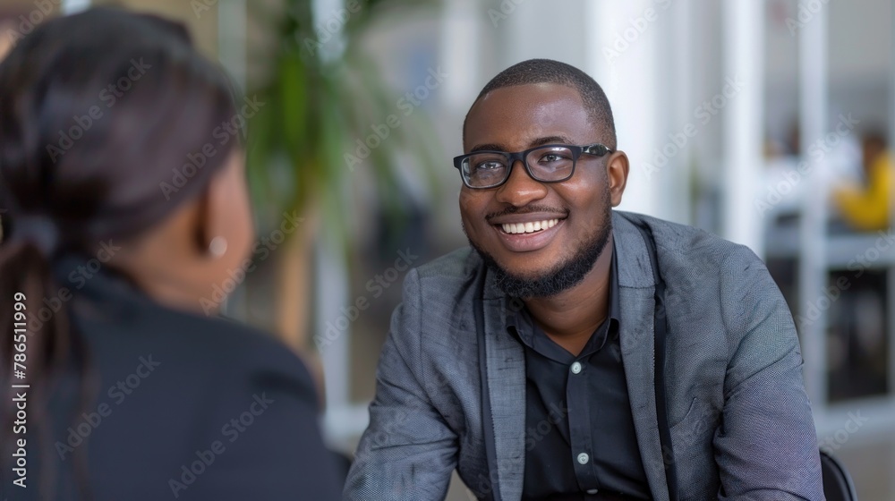 An employee answering interview questions confidently while being assessed by a candidate in a managerial role. An employee answering interview questions confidently while being assessed by a candidate in a managerial role.