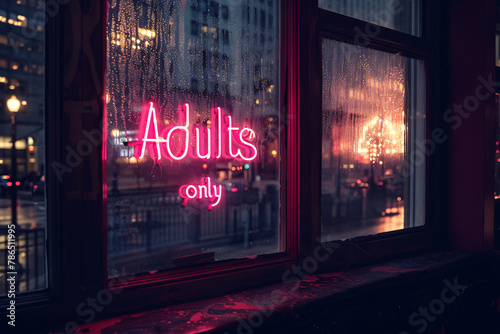 Pink neon light sign with  'Adults only' text hanging in window of bar at night photo
