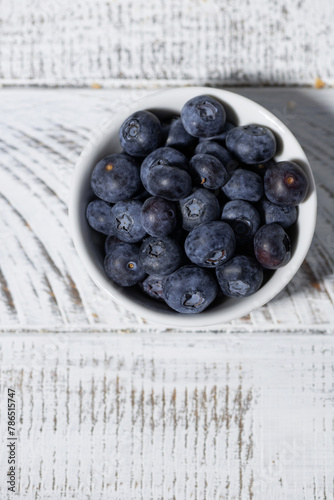 fresh blueberries in a white bowl, vertical
