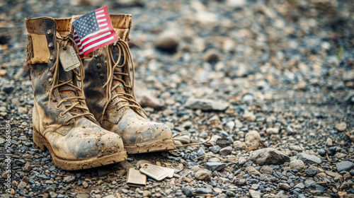 Old military combat boots with dog tags and a small American flag. Rocky gravel background with copy space. Memorial day.