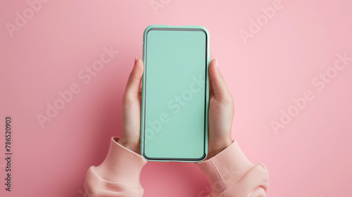 A smartphone with a refreshing mint green casing, in the midst of receiving a congratulatory message, held by the invisible. The backdrop is a gentle pink, representing success with grace. photo