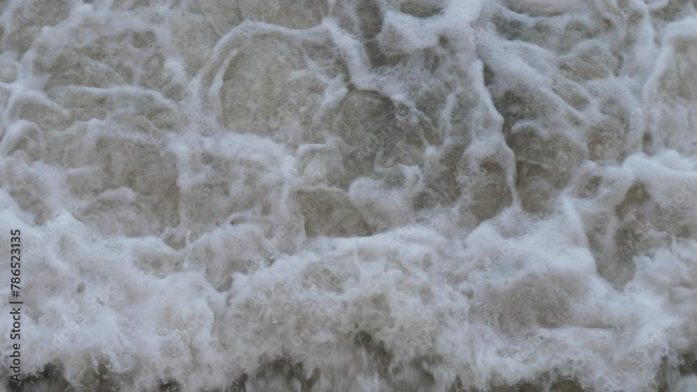 close-up of the rushing foamy waters of a fast river on a waterfall or dam. dumping water into a river during a flood. heavy melting of snow on the river close-up of the rushing foamy waters of a fast river on a waterfall or dam. dumping water into a river during a flood. heavy melting of snow on the river