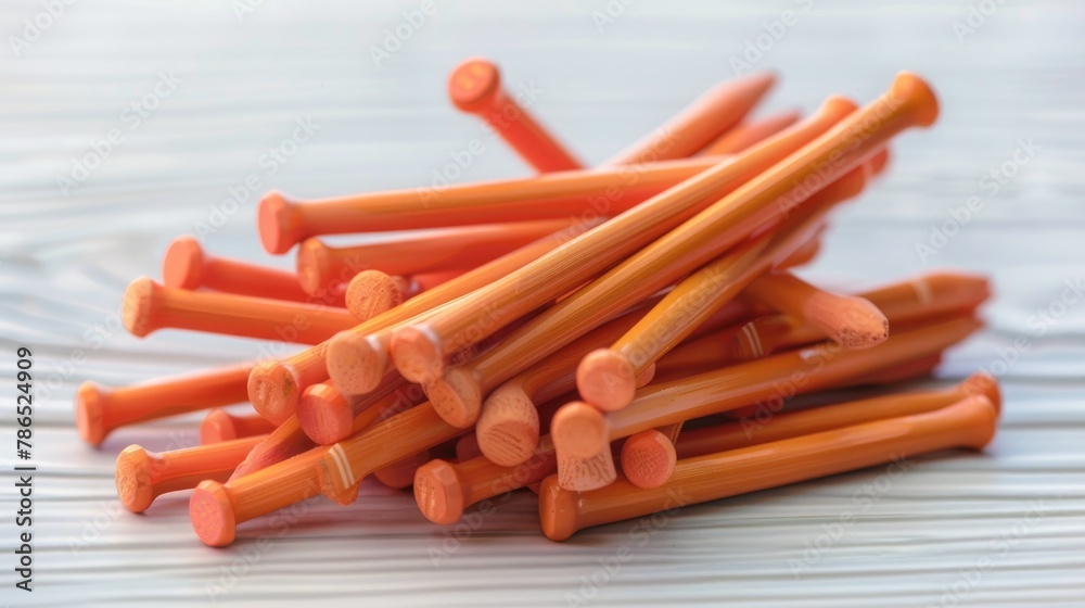 Wooden golf tees in orange color stacked on a white table