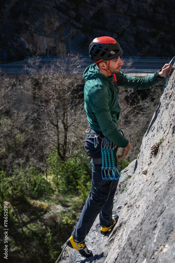 Fototapeta premium Caucasian male with black hair. Practicing rock climbing looking straight ahead.