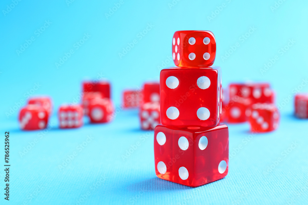 Many red game dices on light blue background, closeup Many red game dices on light blue background, closeup
