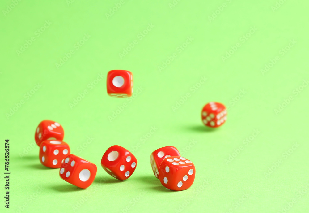 Many red game dices falling on green background. Space for text Many red game dices falling on green background. Space for text