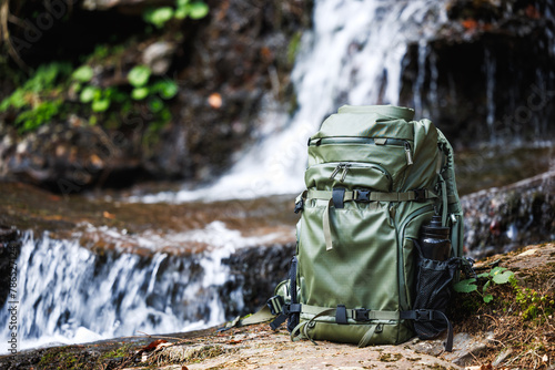 Bild auf Leinwand Hiking backpack made of waterproof fabric in the forest by the river near the waterfall