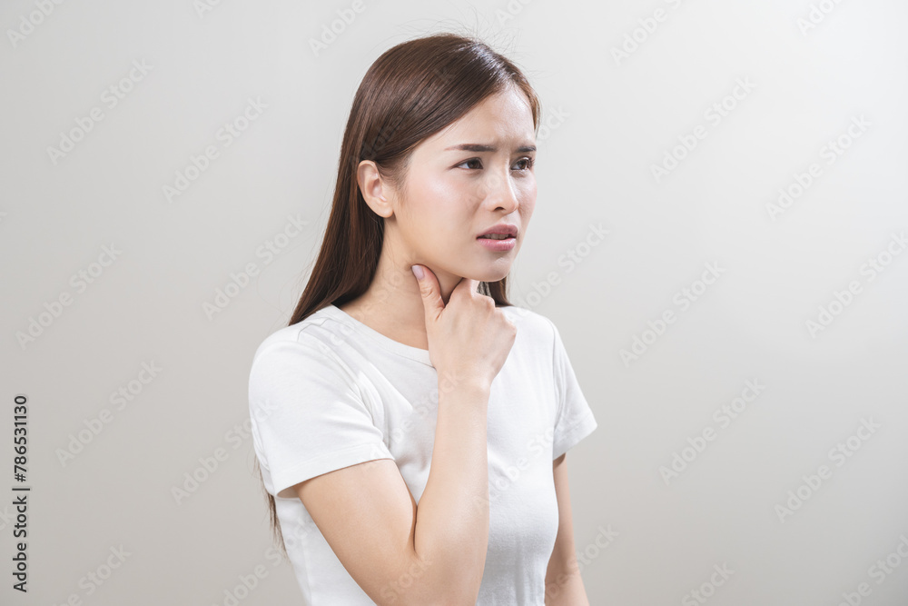 Sickness in inflaming asian young woman, girl use hand check self touch at sore throat, pain thyroid gland on neck or disease reflux, acid of suffer people on wall background. Medical and healthcare. Sickness in inflaming asian young woman, girl use hand check self touch at sore throat, pain thyroid gland on neck or disease reflux, acid of suffer people on wall background. Medical and healthcare.