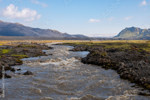 Amazing Icelandic landscape with snowy volcano, stream and mountains on a sunny day at famous Laugavegur hiking trail