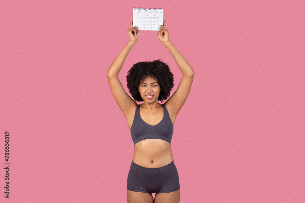 Concerned African American woman holding a calendar - obrazy, fototapety, plakaty 