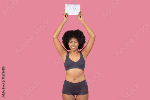 Concerned African American woman holding a calendar
