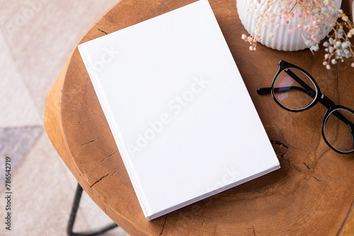 blank book mockup on coffee table with decoration flowers and colorful rug