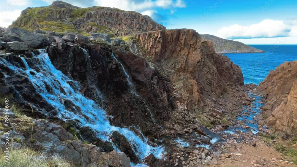 Battery waterfall in Teriberka. Arctic landscape with a view of a flowing waterfall in the northern fjord. The waterfall flows from the lake and flows into the Barents Sea. Arctic, Russia. 4K Battery waterfall in Teriberka. Arctic landscape with a view of a flowing waterfall in the northern fjord. The waterfall flows from the lake and flows into the Barents Sea. Arctic, Russia. 4K