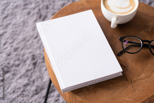 blank book mockup on coffee table with decorations and grey rug
