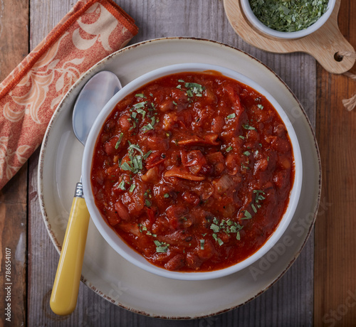 Southern baked beans and bacon strips,garnished with herbs.