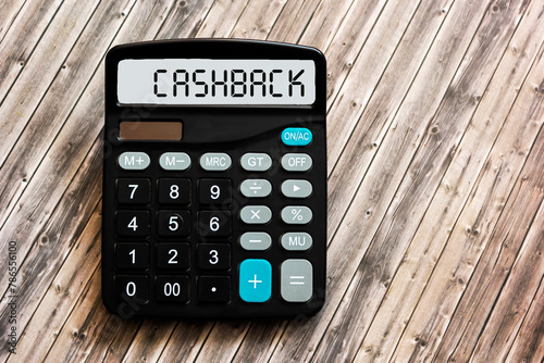 Calculator with the word Cashback on a wooden background, close-up