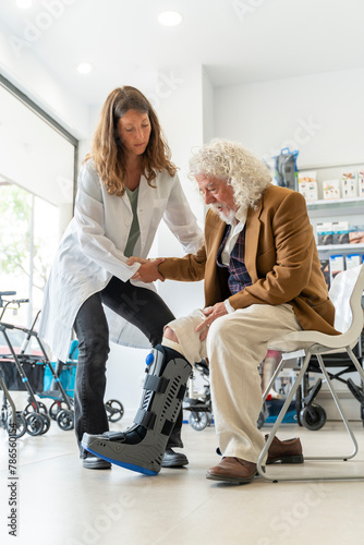 Senior man tries on an orthopedic boot at the pharmacy