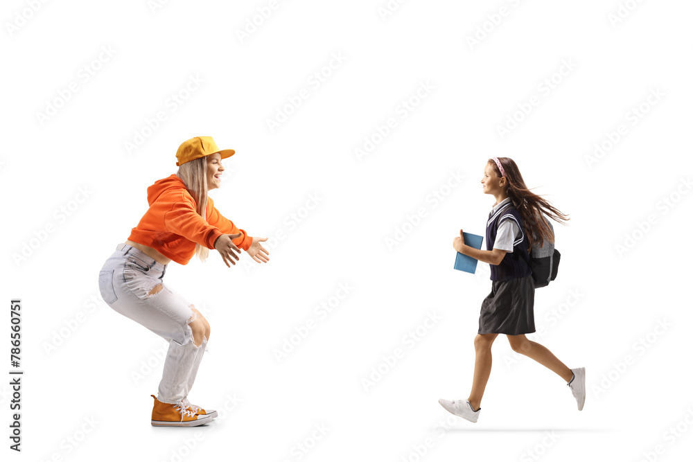 Full length profile shot of a schoolgirl running towards a young female with arms wide open Full length profile shot of a schoolgirl running towards a young female with arms wide open