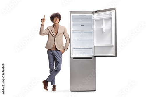 Young man pointing up next to a new fridge © Ljupco Smokovski