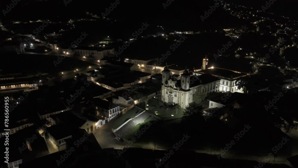 Drone flies over Igreja de Nossa Senhora do Carmo to Praça Tiradentes in Ouro Preto, Brazil at night