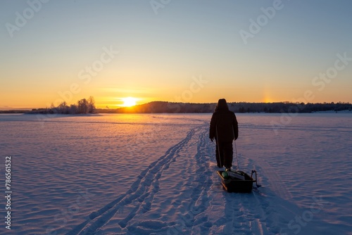 a man goes winter fishing in the north of Karelia photo