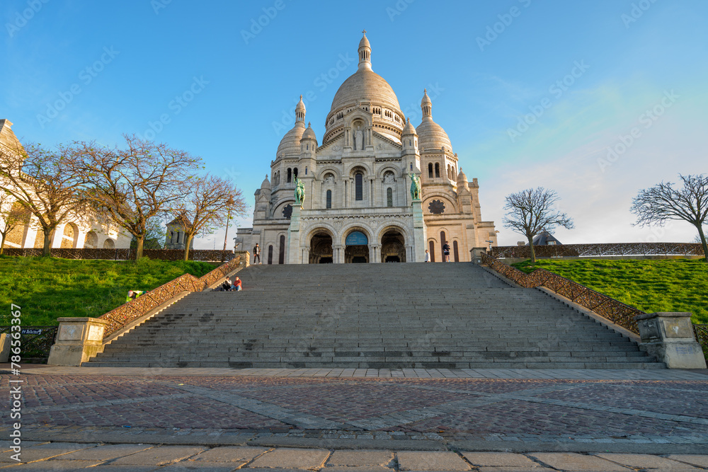 Sacré Coeur de Montmartre et ses escaliers sous un ciel bleu à Paris vus du bas des escaliers au petit matin