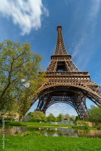 Tour Eiffel près de l'eau et au milieu des arbres sous un ciel bleu à Paris © Joachim Beauvilain