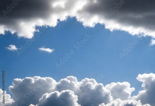Cumulus clouds in a blue sky with varying tones of white  sunlight filtering through at different angles
