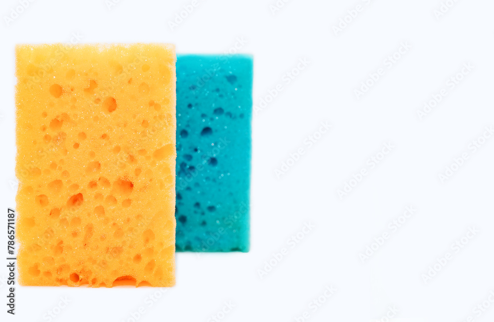 Sponges for washing dishes in the kitchen isolated on a white background with free space for text. New yellow and blue kitchen sponge for cleaning close-up. Cleaning concept