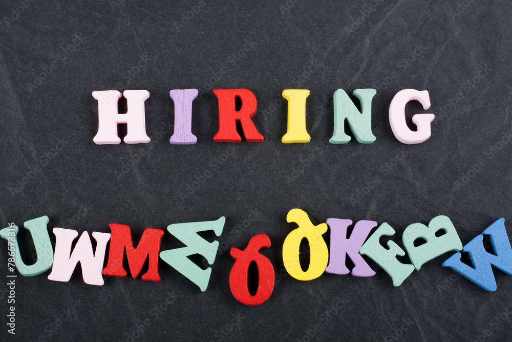 HIRING word on black board background composed from colorful abc alphabet block wooden letters, copy space for ad text. Learning english concept. HIRING word on black board background composed from colorful abc alphabet block wooden letters, copy space for ad text. Learning english concept.