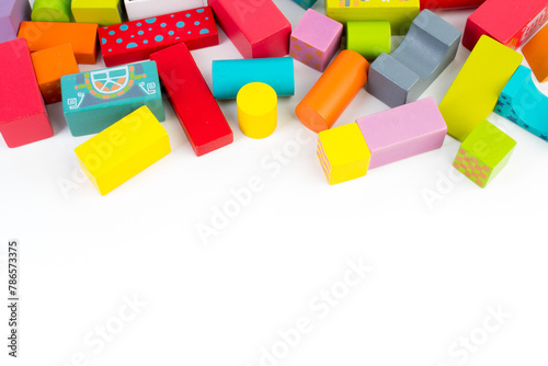Top view of colorful wooden bricks on the table. Early learning. Educational toys on a white background.