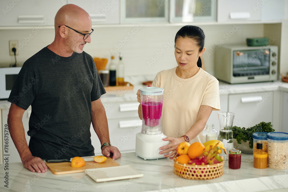 Diverse couple making dragon fruit smoothie for breakfast