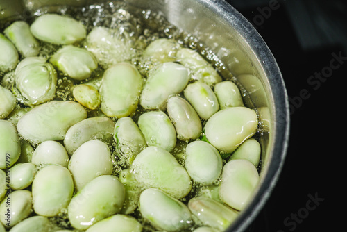 fresh greens broad beans fava boiled on a dark background