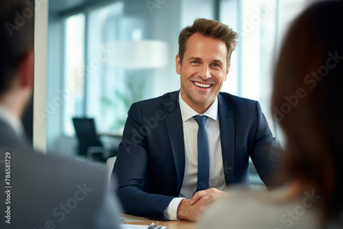 Cheerful businessman having meeting with coworkers in office