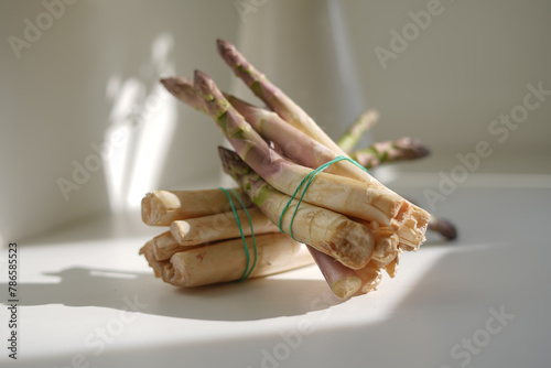 Large fresh raw asparagus on a white table background in daylight photo