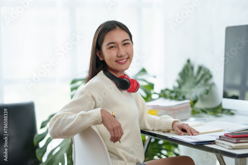 Asian student girl with headphones smiling at the camera.