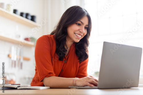 Positive woman working on a laptop at home