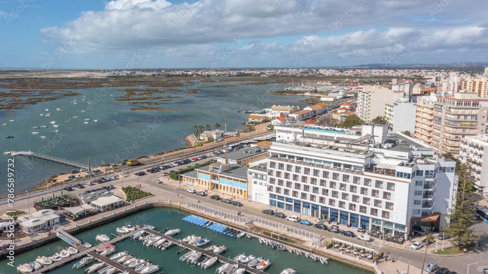 Panoramic aerial view taken by drone of the coastal town of Faro overlooking the Ria Formosa. On a bright sunny day.