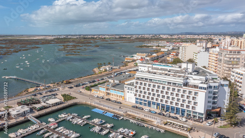 Panoramic aerial view taken by drone of the coastal town of Faro overlooking the Ria Formosa. On a bright sunny day.
