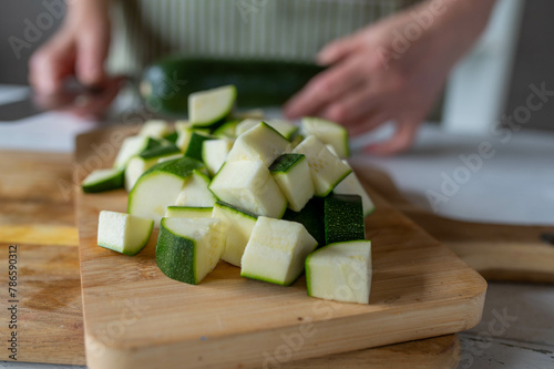 Photography Chopped and  cubed raw  zucchini or green squash on a cutting board in the kitch