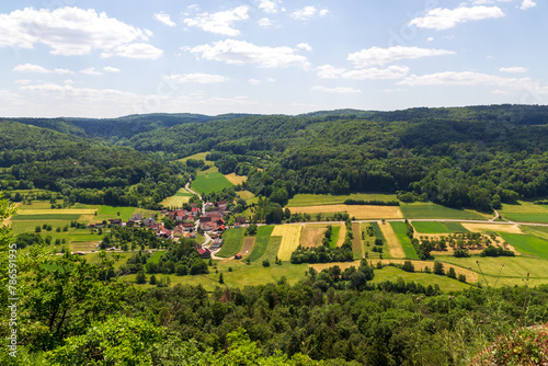 Rural scene with hill panorama, meadows, forest, houses of village Oberzaunsbach in Franconian Switzerland, Germany