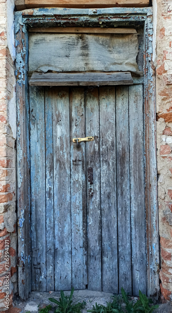 old wooden door with a peeling paint with a lock