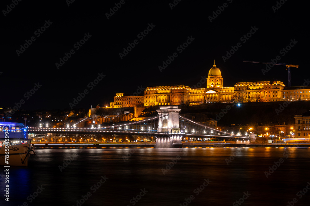 Night photo of Budapest city waterfront with Castle Hill and famous landmarks rising above Danube river Night photo of Budapest city waterfront with Castle Hill and famous landmarks rising above Danube river