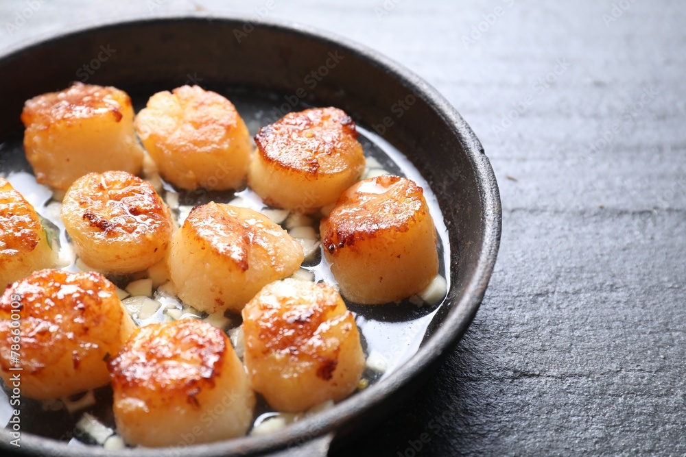Delicious fried scallops in dish on dark gray textured table, closeup Delicious fried scallops in dish on dark gray textured table, closeup